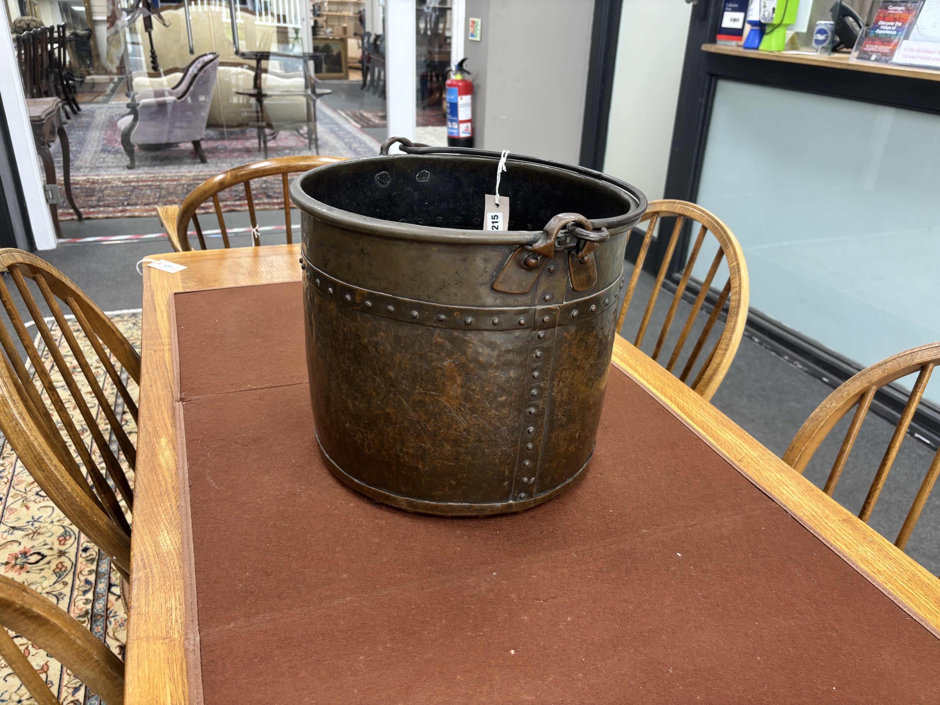 A late Victorian Arts and Crafts hammered copper coal bucket with iron swing handle, diameter 34cm, height 31cm.